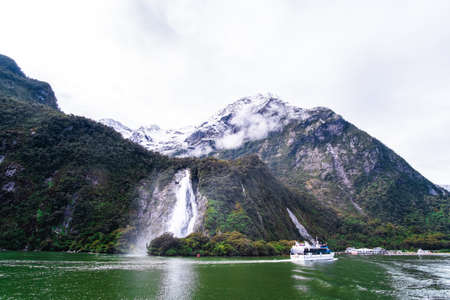 A stunning scene of nature with snow mountain and waterfalls at Milford Sound, New Zealand.の写真素材
