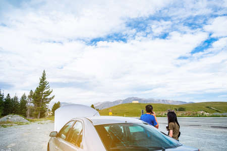 A car broke down beside the highway road. A man calling an insurance.