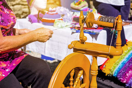2019 FEB 12, New Zealand, Cromwell, A lady using the old traditional wooden yarn machine in market..