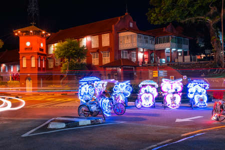 2019 May 8th, Malaysia, Melaka - Long exposure view of the building car and rickshaws beside the road at night..のeditorial素材