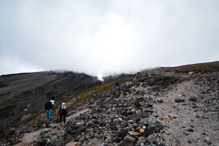 People are hiking on the volcano mountain. Summit track, Mount Taranaki, New Zealand.