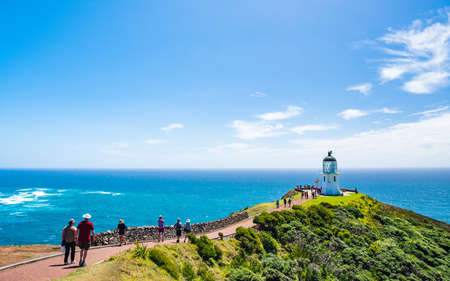 2019 February, 24th, New Zealand, Northland, Cape Reinga - People visit the heritage lighthouse and the most northern point in the country. The beautiful scenery of the landscape with ocean and blue sky.のeditorial素材