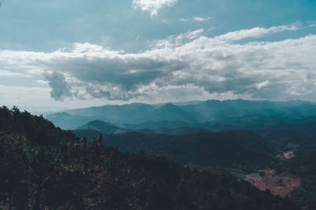 Landscape view of the mountain peaks. A cloudy scene with sun rays, Dramatical photo style. View from Phu Chi per, Mae Hong Son, Thailand.の写真素材