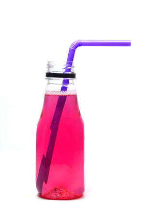 The reddish-pink colored water is packaged in a clear plastic bottle. with purple drinking strawの写真素材