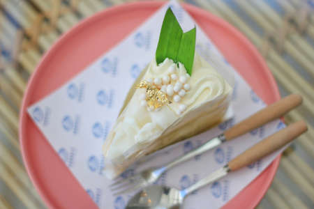 Vanilla cake mixed with coconut, decorated with gold leaf.