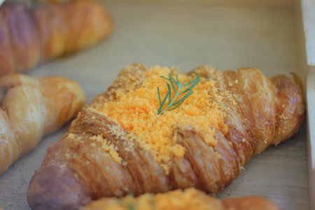 Bread croissant topped with crispy powder and decorated with romery leavesの写真素材