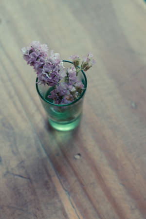 Glass of water with beautiful pink flowers vintage wallpaper.の写真素材