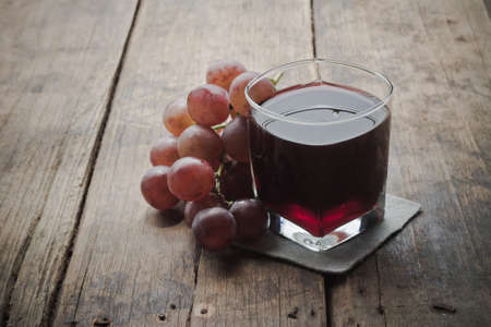 Grape juice on a wood background.の写真素材