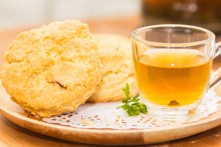 Place the scones on a plate, dessert and tea on wooden flooring.の写真素材