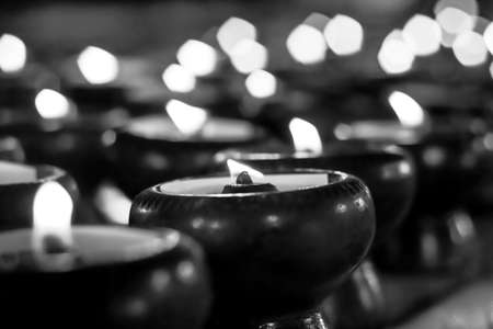 Light a candle in the dark, blur, black and white background.の写真素材