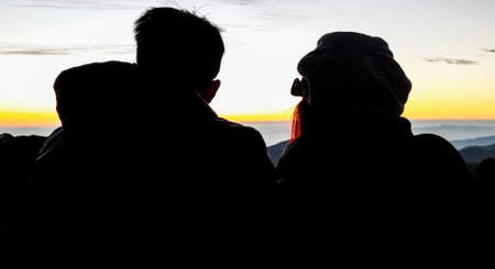 Men and women who love romantic silhouette sun rising in the morning.の写真素材