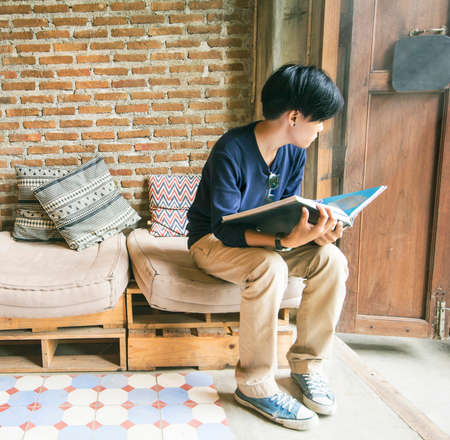 Blur man reading while sitting on a chair, the Public Library Vintage background.の写真素材