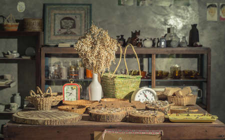 Jewelry, watches, rings, distributed flowers and fruit basket of household appliances placed on a wooden table. , In the dark grain and noise.の写真素材