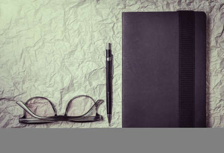 Glasses, books, pencil on paper, crumpled light Sunlight vintage tone.の写真素材