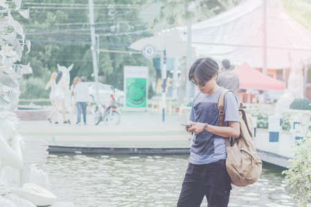 Blur tourists in Thailand are holding a mobile view. Sunlight exposure vintage tone.の写真素材