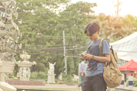 Blur tourists in Thailand are holding a mobile view. Sunlight exposure vintage tone.の写真素材
