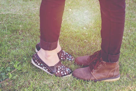 Men's shoes and women's shoes on the grass with sunset light.の写真素材