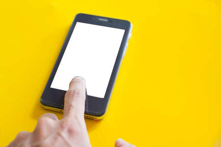 Hand touch mobile space white on yellow backgroundの写真素材