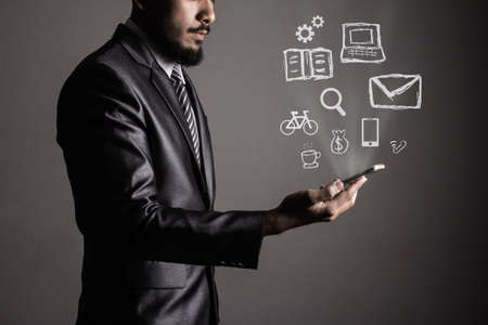 Business man holding a smartphone with social media icon concept.