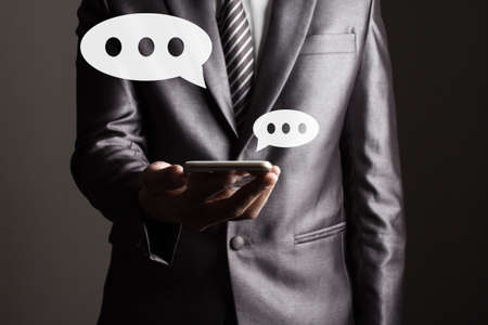 Business man holding a smartphone with social media icon concept.の写真素材
