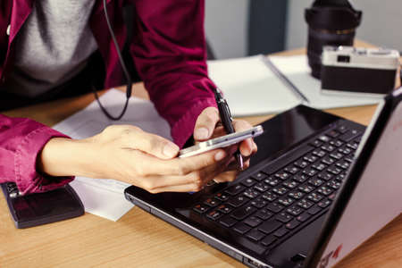 Man work on mobile phone and computer business concept Vintage tone.の写真素材