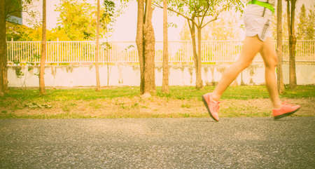 Motion blur close up runner's legs run on the street with light Sunset background.の写真素材