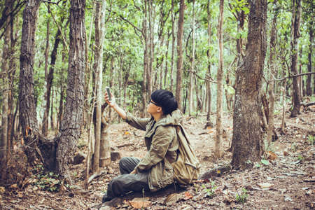 Man hand holds a mobile phone map tourism of the forest in Holiday Travelの写真素材