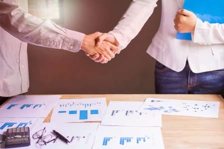 Businessmen together create a mutually beneficial business relationship. Economic graph on the tableの写真素材