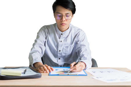 Asian young business man working on a table with graphing plans. To meet the results in the day ahead, Isolated white background.の写真素材