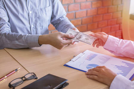 Money bank dollar United States handing was paid to customers stock trading business graph report work on wood tableの写真素材