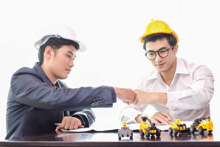 Hand close up young Asian business team work . Industrial engines and trucks. To achieve success on white background.の写真素材