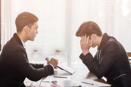 Two men  Asian business meeting, man sitting stress with work on the tableの写真素材