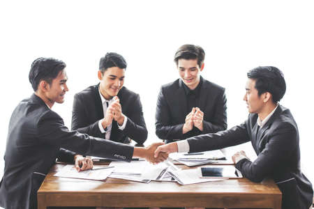 Asia business people Shake hand Cooperating relationship teamwork They smile sitting on chair at the office with her colleagues.の写真素材