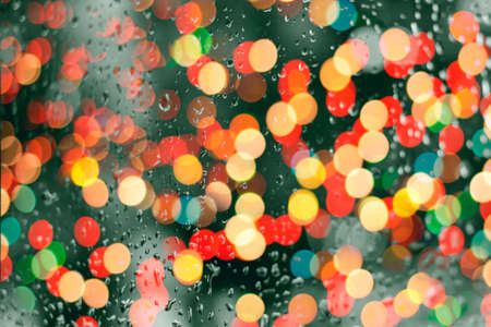 Rain drop on window glass. Road light bokeh colorful. Vintage Tone, Abstract background.