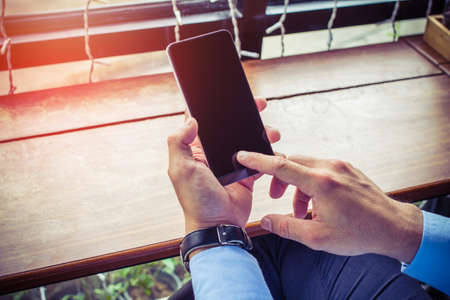 Close up of men hands holding touching mobile phone with blank copy space for your text message on...