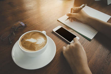 Soft and blurry,teenager hand, writing pencil holder, cell phone touching, Black space for text,...