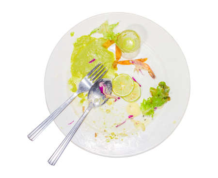 Food waste, after eating steak, fish sauce, chili, lime, purple cabbage, shrimp and dirty spoon in the dish. Isolated white background.の写真素材