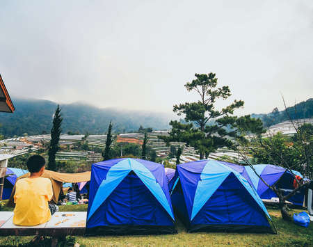 Boy tourists, sitting back looking at the mountains and clouds in the New Year's Eve countdown begins before the New Year.の写真素材