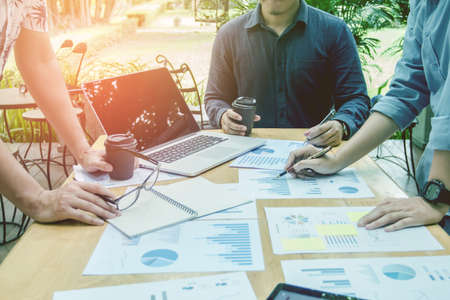 Start up business. people holding pen ,Team work meeting point to discuss the graph up and down of...
