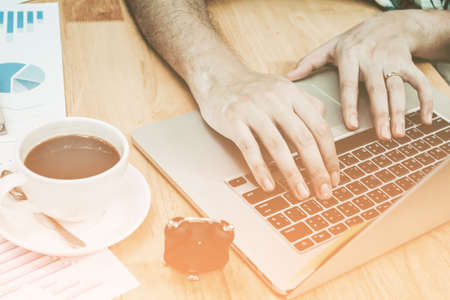 Close up. Man's hands Working on laptop connecting networking and Hacker Concept, With coffee cup , Sunset, Selective Focus.の写真素材