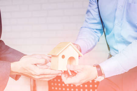 Close up of Asian young business people are giving new house in future success on office with sunsetの写真素材