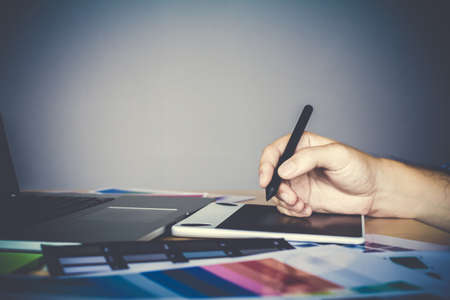 Designer graphic creative working on mouse pen, laptop in officeの写真素材