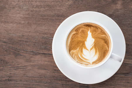 Coffee cup latte art on wooden. Copy space for your text