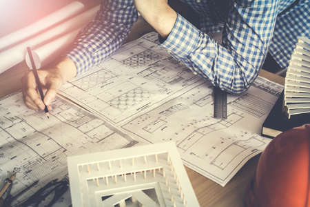 Concept architects,engineer holding pen pointing equipment architects On the desk with a blueprint...