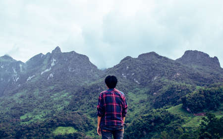 Rear view of an Asian young man in Scottish shirt at mountain peak above clouds and fog Hiker outdoor. Doi Luang Chiang Dao Chiang Mai Province in the morning.の写真素材