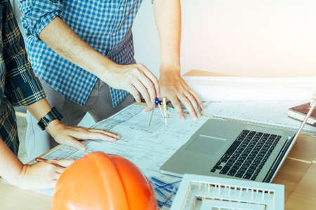Concept architects, Two asian engineer pointing equipment architects On the desk with a blueprint in the office, Vintage, Sunset light.Selective Focusの写真素材