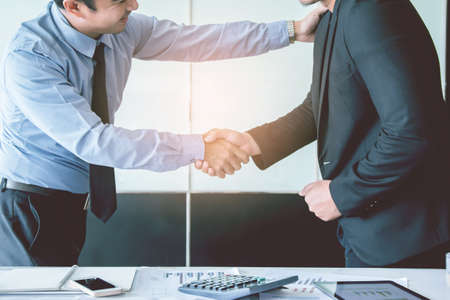 Asia Businessman together create a mutually beneficial business relationship. Economic graph on the tableの写真素材