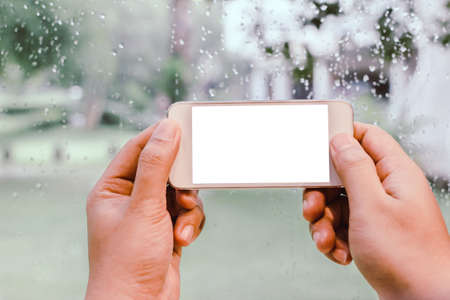 Man hands holding smart phone with white blank copy space screen for your text message, reading text ,message on cell telephone  mail.の写真素材
