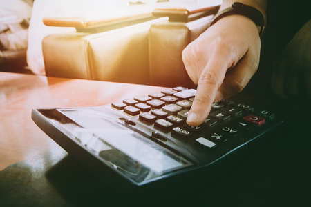 Close up man hand using calculator Calculating bonus(Or other compensation) to employees to increase productivity on desk.Selective Focusの写真素材