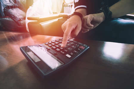 Close up man hand using calculator Calculating bonus(Or other compensation) to employees to increase productivity on desk.Selective Focusの写真素材